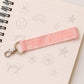 Girl Power fabric ribbon keychain with vibrant pink embossed strap on metal ring