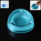 Transparent plastic ashtray with three cigarette rest slots and wide bowl