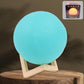 A serene blue Moon Night Lamp illuminating a dark room, creating a calming ambiance.