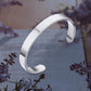 Minimalist silver-tone stainless steel bracelet with open-ended design