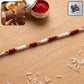 Handmade red and white thread Rakhi with pearl beads and golden accents