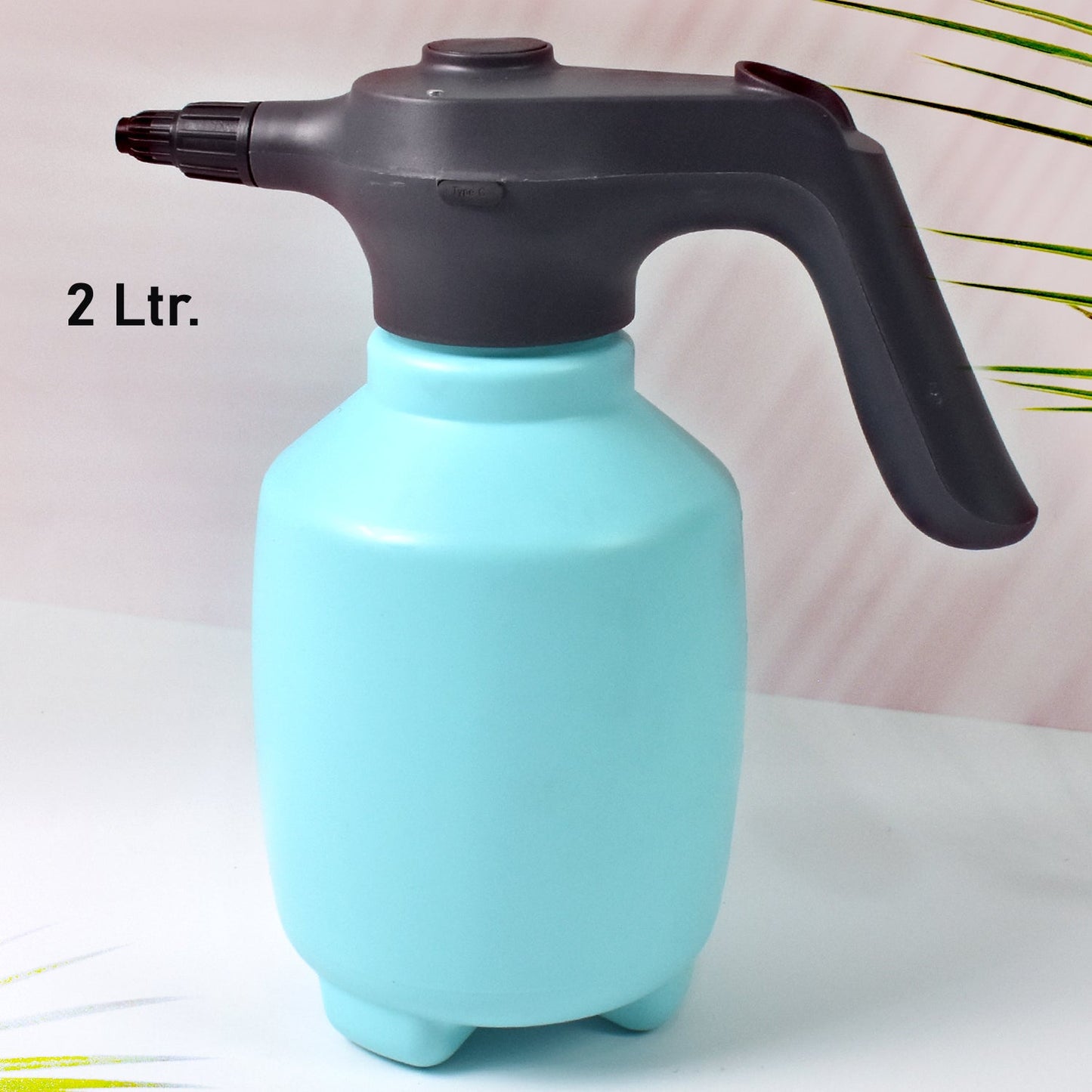 Electric garden sprayer in use, watering a plant with a fine mist.