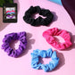 Set of four soft elastic hair scrunchies in assorted colors displayed on a white background.