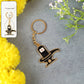Golden Shivling keychain in metal with intricate design on plain background