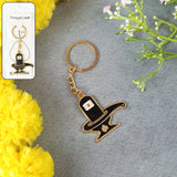 Golden Shivling keychain in metal with intricate design on plain background