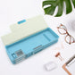 Two-compartment plastic stationery box, ideal for separating different types of school supplies.
