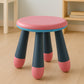 A young child seated comfortably on the Bub Barrier foldable baby stool.
