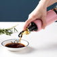 Vastate 300ml olive oil dispenser with a non-drip spout, shown against a clean kitchen background.