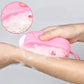 Double-sided silicone bath brush shown in use for a thorough skin cleanse.