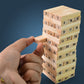 Hands carefully removing a block from the tumbling tower, demonstrating the focus required for the Wooden Stacking Game.