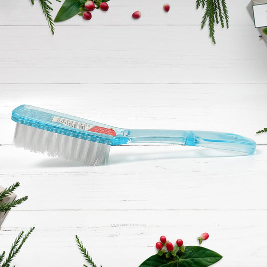 Ergonomic scrubbing brush being used to clean the sole of a shoe.