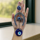 Close-up of alloy metal evil eye hanging with chain and elephant motif