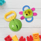 Close-up of baby's hand grasping an ergonomic yellow teether toy
