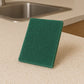 Close-up of heavy-duty scrubber pad used on pan for deep cleaning