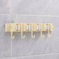 Self-adhesive broom and mop holder rack mounted on wall with utility hooks