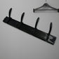 Top-down view of the 4-hook wall mount coat hanger holding various coats and hats.