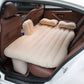 Inflatable car bed with two pillows and pump set up in a car's back seat.
