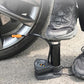 A person using the foot bike pump to quickly inflate a sports ball.
