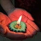 A single lit silicone diya glowing warmly on a dark surface, enhancing its festive appeal.