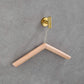Close-up of a natural wood clothes hanger, showcasing its smooth finish.