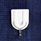 A small adhesive hook in a hallway, perfect for hanging keys and other small items.