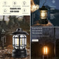 Lightweight retro LED camping lantern hanging from a tree branch in a natural setting.