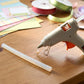 Hot glue stick inserted into a glue gun for precise adhesive application