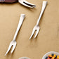 Close-up view of stainless steel fruit fork picking a piece of fruit
