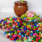 Vibrant decorative pebbles used as vase fillers in a clear glass container.