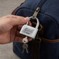 Heavy steel padlock and its keys displayed on a rustic wooden surface.