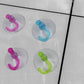 Pack of 12 transparent suction hooks ready for home use.