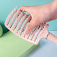 Massage hair comb held by hand showing anti-slip handle for comfortable styling