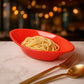 Side view of red oval serving bowl made of durable plastic