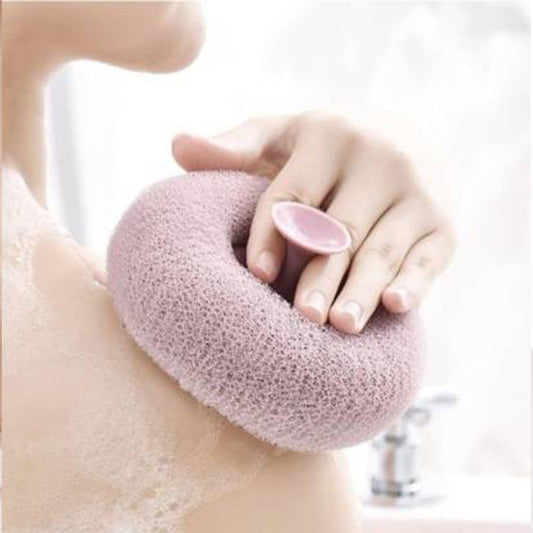 A hand holding the flower-shaped bath sponge during a refreshing shower.