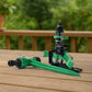 Water spray from rotating garden sprinkler installed in green lawn