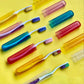 A manual toothbrush securely stored inside a clear plastic travel cover.