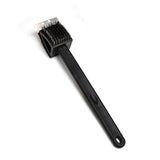 Black silicone toilet brush with its draining holder, ready for use in a modern bathroom.
