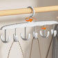 Rotatable 12-hook tank top hanger holding multiple tank tops in a modern closet.