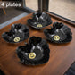Four ceramic tea cups and four plastic leaf-shaped bowls displayed together.