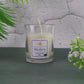 Lit Blueberry Scented Candle with fresh blueberries scattered around it, enhancing the aroma theme.