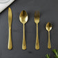 Gold spoons, forks, and knives laid out showcasing the set's completeness