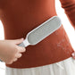 Hand holding the reusable lint brush, demonstrating its easy grip.