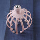 Hand holding a scalp massager, demonstrating its use for stress relief.
