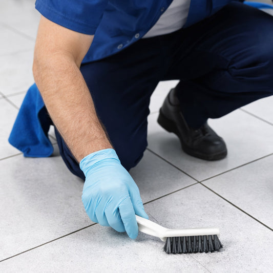 Cleaning brush scrubbing tile gaps for effective household cleaning