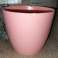 Round plastic planter in a modern indoor setting, demonstrating its versatility.