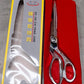 Top-down view of Cisora's gold-plated cloth cutting scissors, highlighting precision.