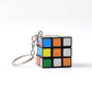 Close-up of a Mini Magic Cube Puzzle keychain on a clean white background.