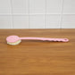 Velvet Wipe back scrubber demonstrating its extended handle for full back coverage during bathing.