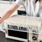 Elasticated plastic couch protector securely fitted over a sofa.