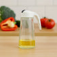 Glass oil bottle dispenser showing measuring marks and leak-proof spout